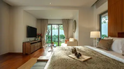 Luxurious bedroom with garden view, elegant decor, and natural light.
