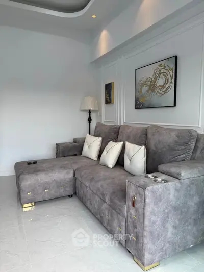 Luxurious modern living room with plush gray sectional sofa and elegant wall art, perfect for relaxation.