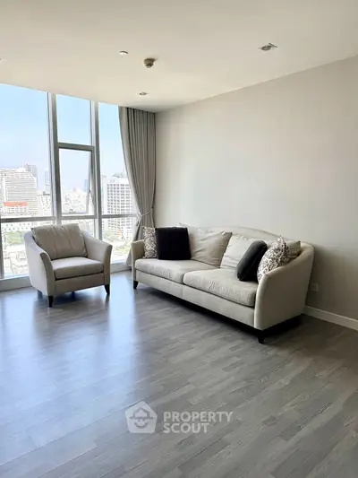 Spacious living room with modern furniture and city view, perfect for urban living.