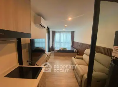 Modern studio apartment with open layout, featuring cozy living area and sleek kitchen.