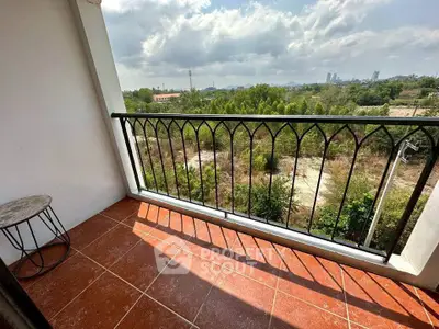 Charming balcony with scenic view of lush greenery and city skyline, perfect for relaxation.