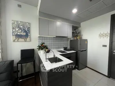 Modern kitchen with sleek cabinets and stainless steel appliances in a cozy apartment.