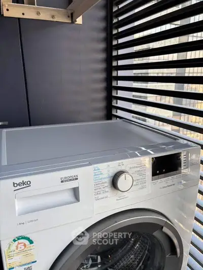 Modern washing machine on a stylish balcony with sleek slatted design, perfect for urban living.