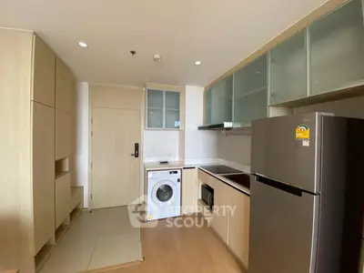 Modern kitchen with washing machine and fridge in compact apartment