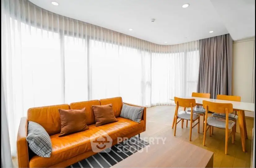 Spacious living room with modern furniture and large windows in a luxury apartment.