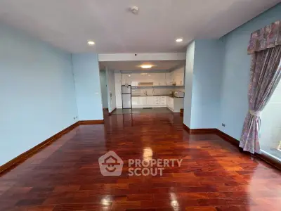 Spacious living room with hardwood floors and open kitchen layout