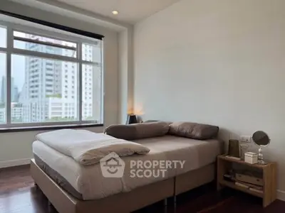 Modern bedroom with large window offering city view and cozy decor