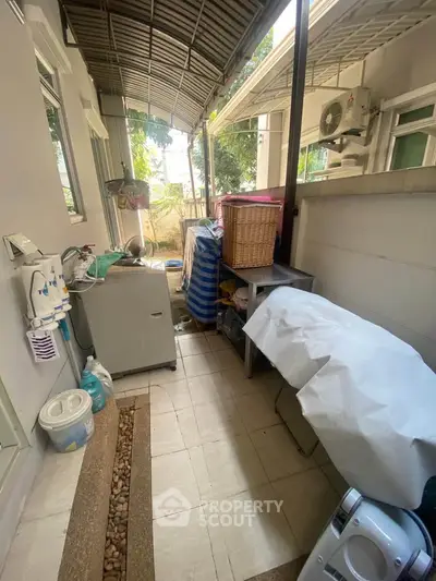 Outdoor storage area with covered roof and various household items