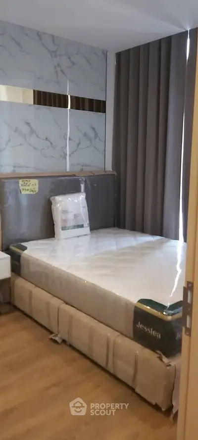 Modern bedroom with stylish decor and new mattress in a contemporary apartment.