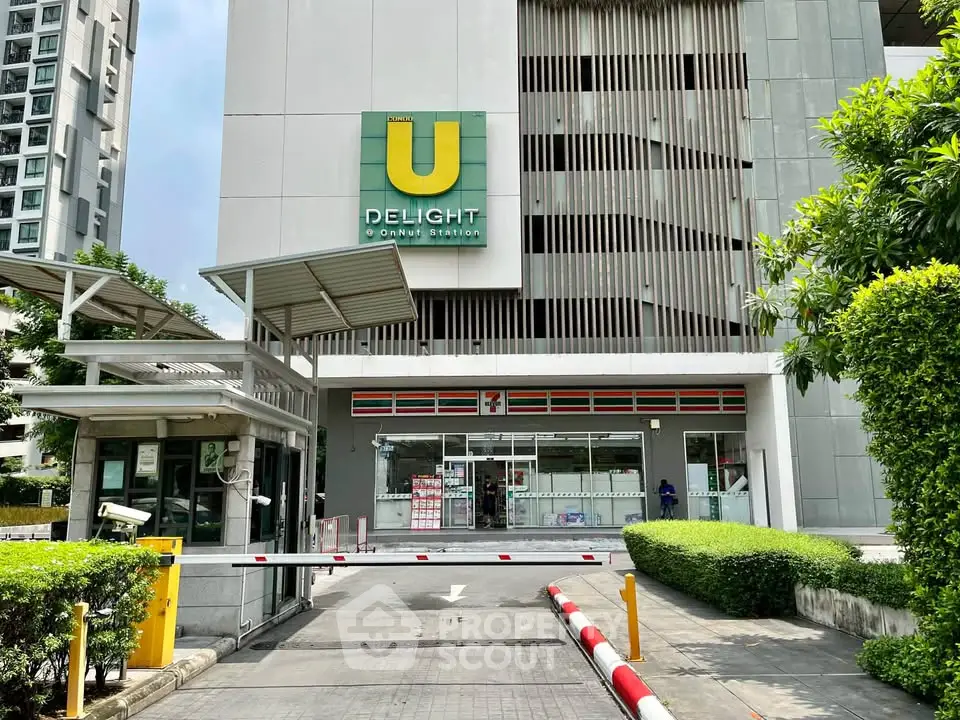 Modern condominium entrance with convenient store and lush greenery, ideal urban living.