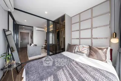 Modern bedroom with stylish decor and open layout leading to living area, featuring elegant furnishings and ample natural light.