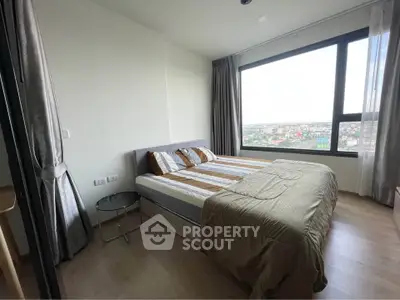 Modern bedroom with large window offering stunning city view