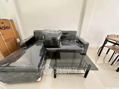 Modern living room with sleek black sofa and glass coffee table