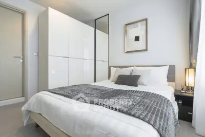 Modern bedroom with stylish decor and cozy ambiance, featuring a comfortable bed and elegant lighting.