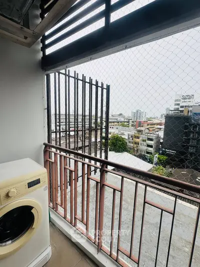 Urban balcony with washing machine and city view, perfect for modern living.