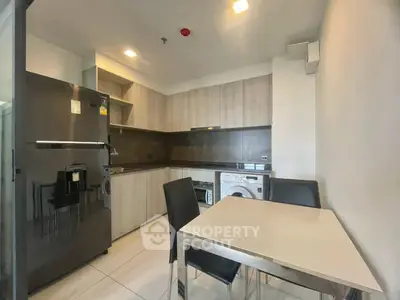 Modern kitchen with sleek appliances and dining area in stylish apartment