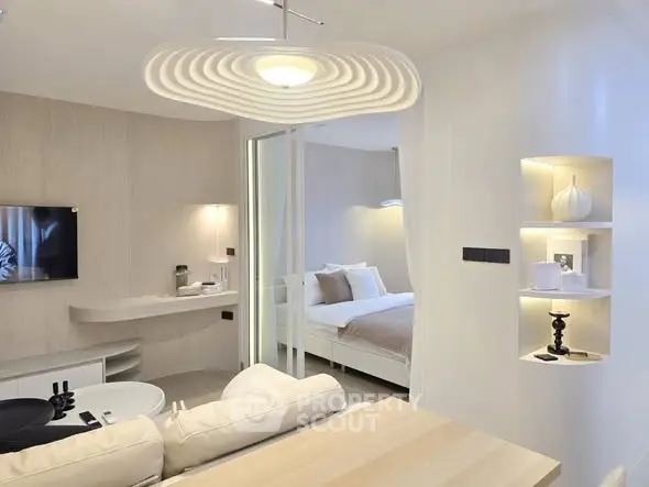 Modern open-plan living room with stylish decor and cozy bedroom view.