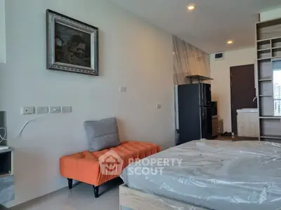 Modern bedroom with stylish decor and compact kitchen area in a cozy apartment.