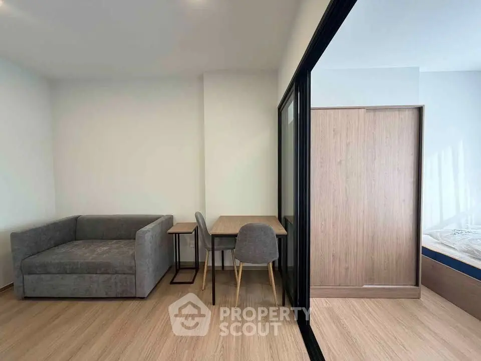 Modern studio apartment with cozy living area and sliding glass partition