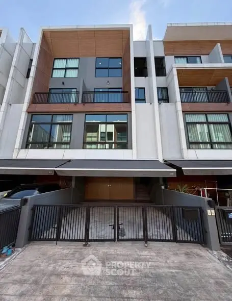 Modern multi-story townhouse with sleek design and gated entrance