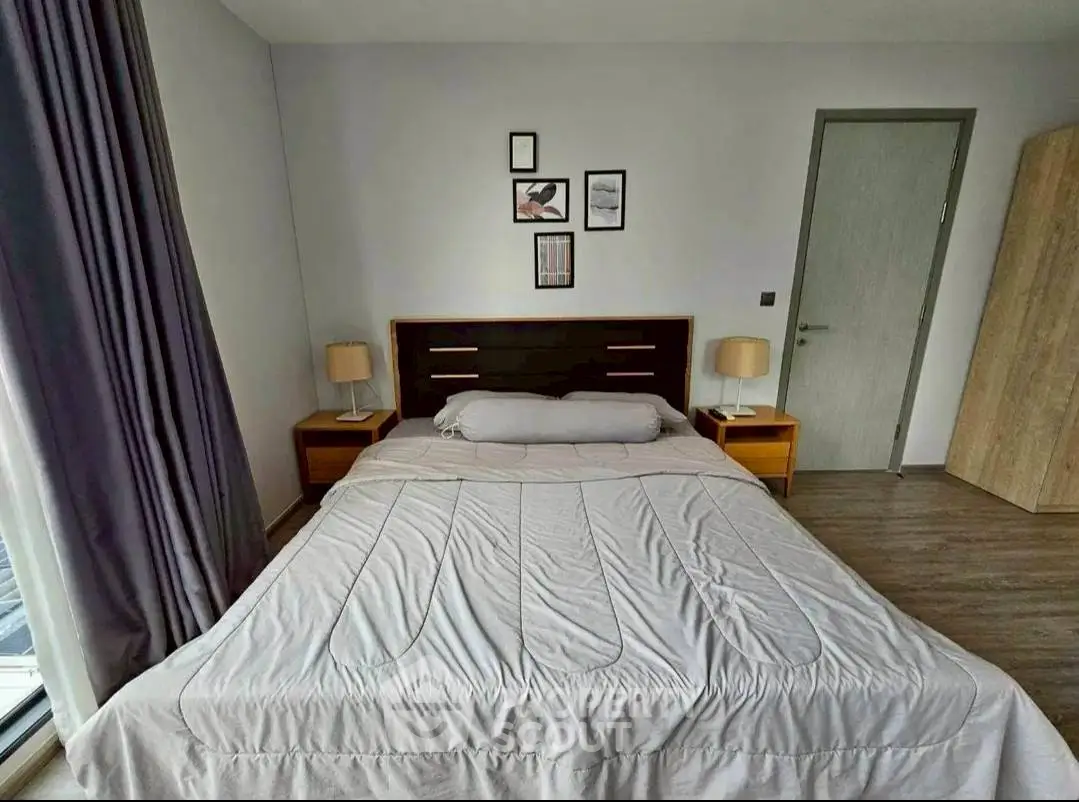 Spacious bedroom with modern decor and large window for natural light.