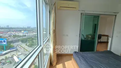 Bright bedroom with large windows offering stunning city views and modern furnishings.