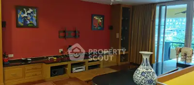 Spacious living room with vibrant red accent wall and balcony view