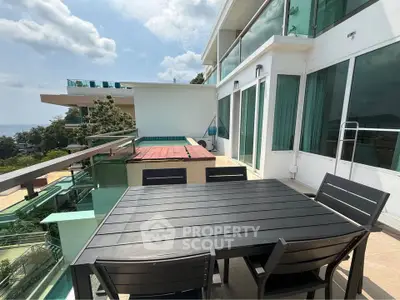 Luxurious balcony with stunning ocean view and modern outdoor dining set.