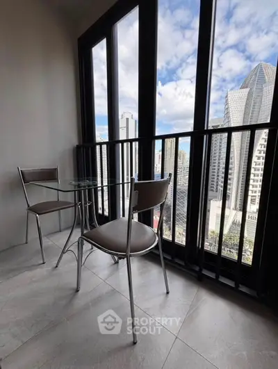 Modern balcony with city skyline view and stylish seating area.