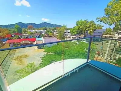 Stunning balcony view with lush greenery and distant mountains, perfect for relaxation.