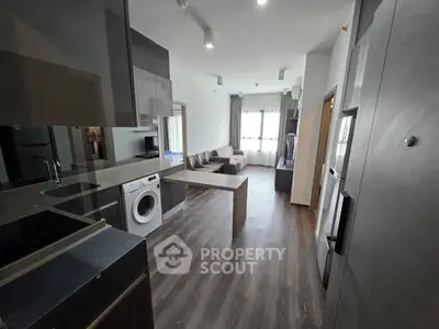 Modern open-layout kitchen with sleek appliances and cozy living area, perfect for urban living.