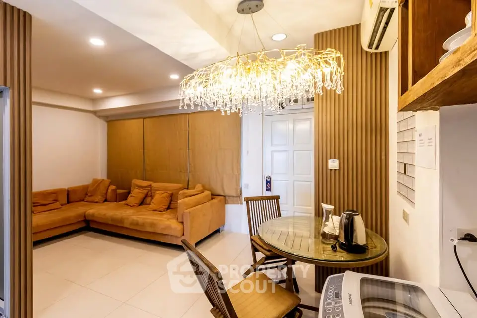 Stylish living room with modern chandelier and cozy seating area in a contemporary apartment.