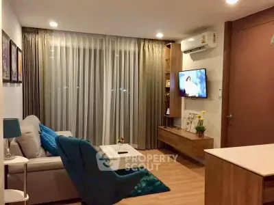 Modern living room with stylish decor and cozy ambiance, featuring a wall-mounted TV and elegant furnishings.