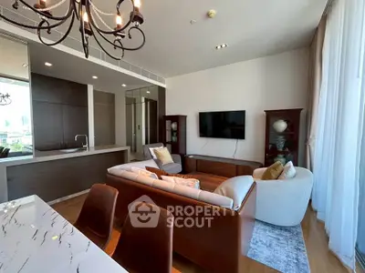 Luxurious living room with modern decor, open kitchen, and elegant chandelier in a high-end apartment.
