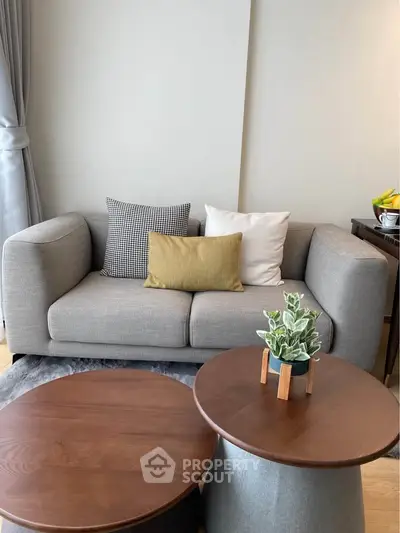 Modern living room with stylish gray sofa and wooden coffee tables, perfect for cozy relaxation.