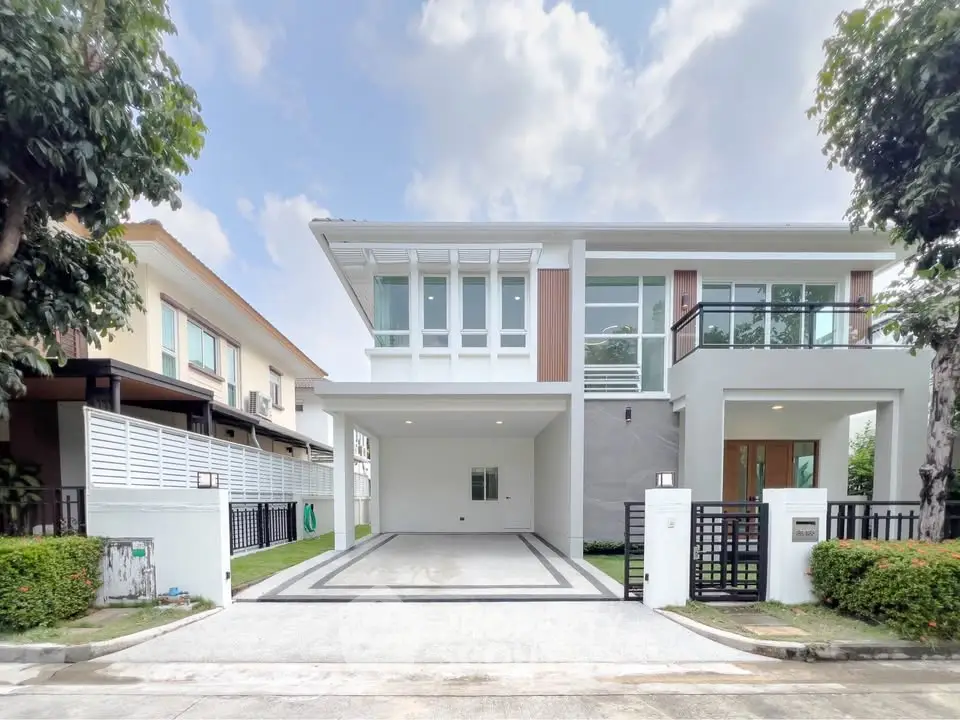 Modern two-story house with spacious driveway and contemporary design in a suburban neighborhood.
