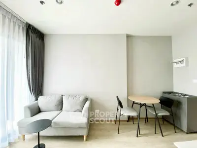 Modern living room with cozy sofa and dining area, featuring elegant curtains and minimalist decor.