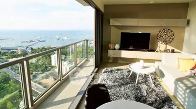 Luxurious living room with stunning ocean view and spacious balcony in modern high-rise apartment.