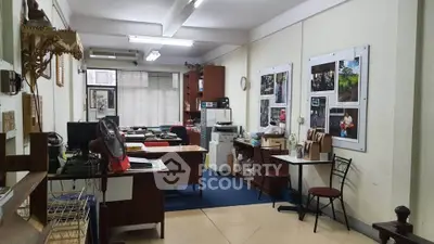 Spacious office interior with desks, chairs, and wall art, ideal for creative workspaces.