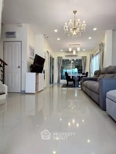 Spacious living room with elegant chandelier and modern furnishings