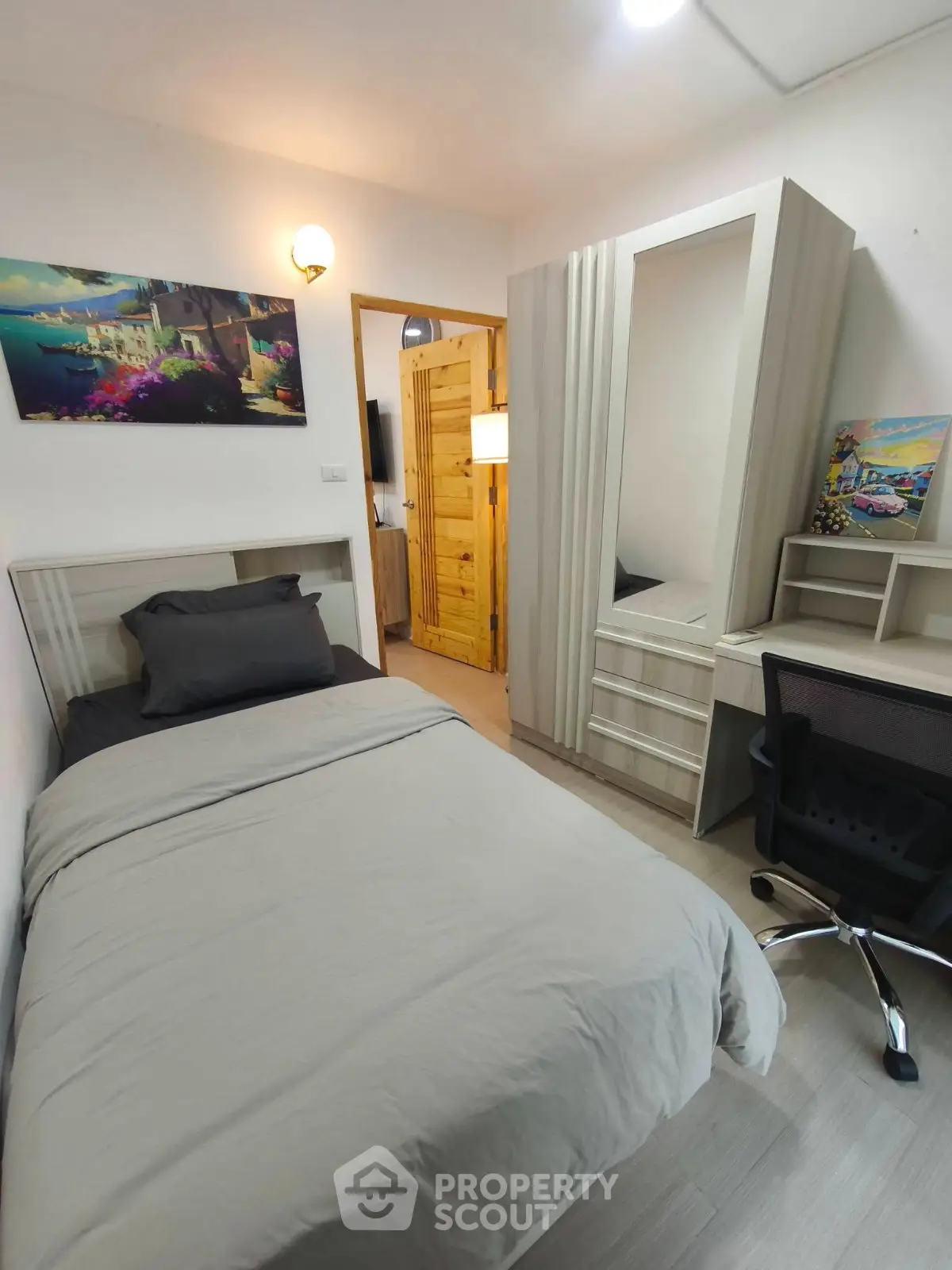 Cozy bedroom with single bed, modern wardrobe, and study desk in a compact layout.