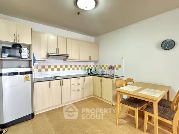 Cozy kitchen with wooden cabinets and dining area, perfect for small families.