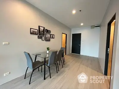 Modern dining area with sleek glass table and stylish chairs in a contemporary apartment.