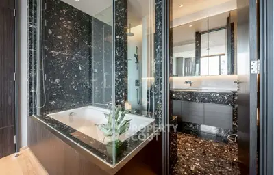 Luxurious modern bathroom with marble finishes and spacious bathtub