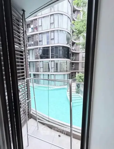 Modern apartment balcony with pool view and sleek glass railing