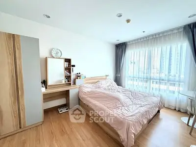 Spacious bedroom with natural light and modern wooden furniture