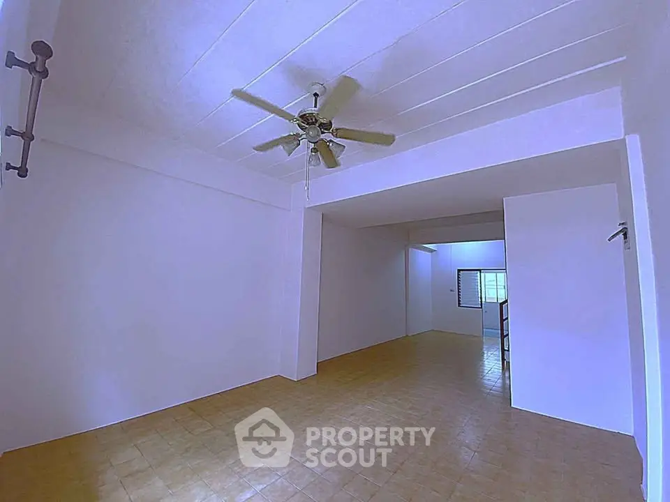 Spacious open-plan room with ceiling fan and tiled flooring, ideal for versatile living arrangements.