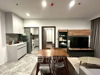 Modern living room with open kitchen and stylish dining area in contemporary apartment.