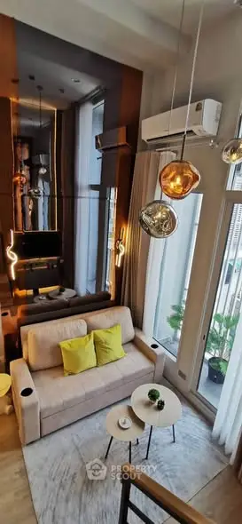 Modern living room with high ceilings, stylish lighting, and large windows for natural light.