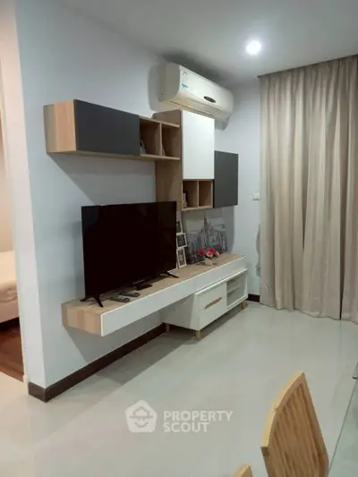 Modern living room with sleek TV unit and air conditioning, perfect for cozy relaxation.